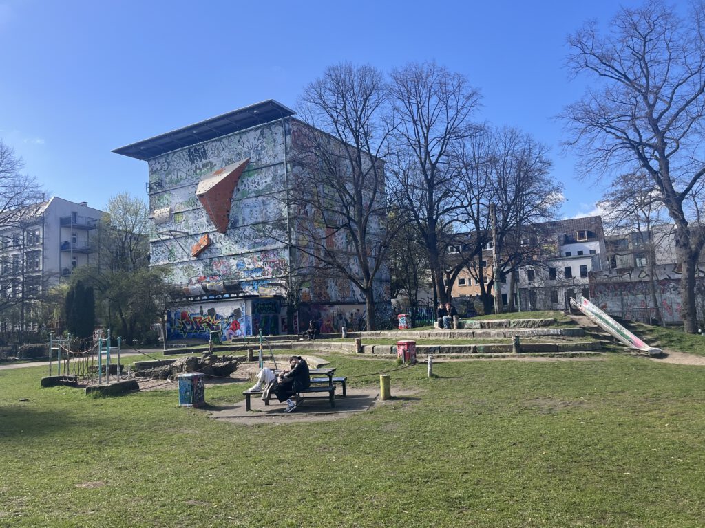 Park im Szeneviertel mit bunt bemaltem Gebäude und Kletterwand