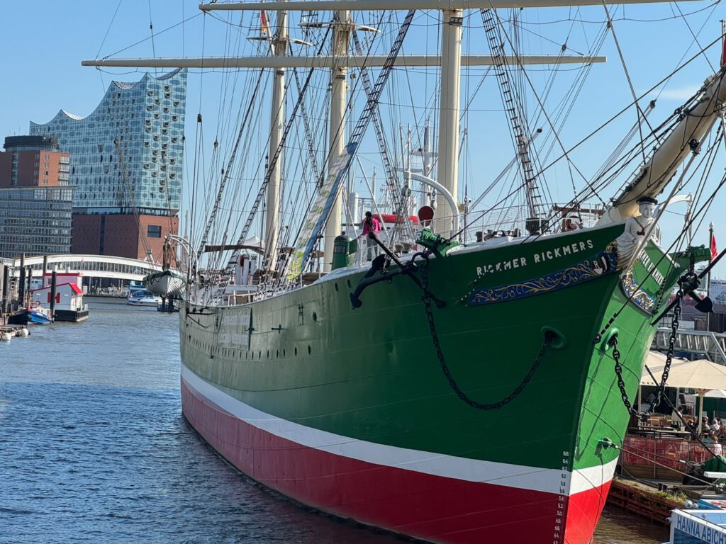 Grüner Großsegler im Hafen, dahinter die Elbphilharmonie